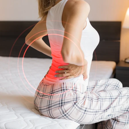A woman holding her lower back, which is highlighted red.