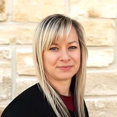 Nurse Practitioner Katie Cruz smiling in front of a stone wall.